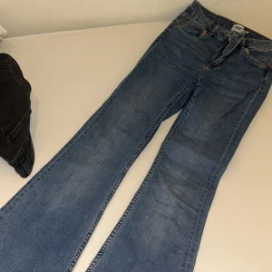 Blå bootcut jeans från 157 - Snygga blå jeans från 157 med klassisk femficksdesign och dragkedja. Modellen har bootcut-ben som ger en schysst retrovibe och är tillverkade i mjukt denimtyg. Perfekta för dig som gillar en avslappnad men trendig look.