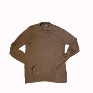 Brun pikétröja i bomull från Dressmann - Säljer en brun pikétröja från Dressmann i mjuk supima-bomull. As najs Slim fit passform och passar till hösten, hör av dig om du har funderingar eller frågor