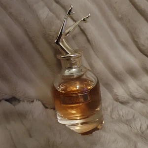 Scandal parfym från Jean Paul Gaultier - Unik parfymflaska från Jean Paul Gaultier, Scandal, med en cool silverfärgad kork formad som ett par ben. Flaskan är rund och genomskinlig med bärnstensfärgad vätska. Perfekt för dig som gillar snygg design och vill sticka ut. Har tyvärr inte kvar kartongen. 