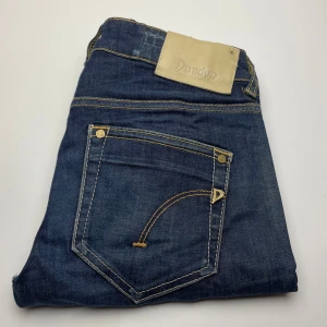 Dondup jeans  - Snygga mörkblå jeans från Dondup med klassiska kontrastsömmar och läderpatch bak i midjan. Jeansen har fem fickor och är tillverkade i slitstarkt denim. Perfekta för dig som gillar en tidlös och clean look.