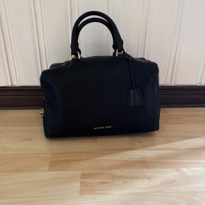 Svart handväska från Michael Kors - Äkta Michael Kors väska i svart läder. Den har stått ett tag nu så den är lite smutsig men inget som inte går att få bort och inga skador på lädret osv. 