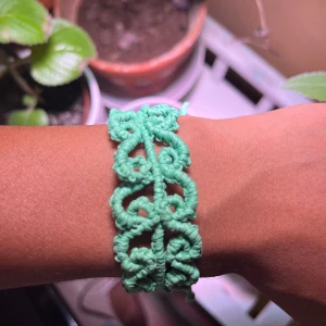 Grönt makraméarmband med knyt - Unikt handgjort armband i ljusgrönt makramé med snyggt flätad och snirklig design. Armbandet har justerbar knytning så det passar de flesta handleder. Perfekt för dig som gillar boho-vibe och vill ha något personligt och färgglatt på armen.