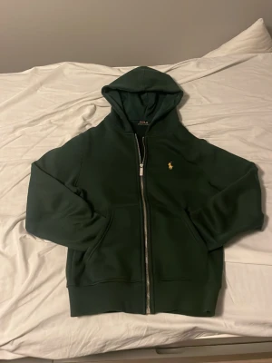Grön Ralph lauren tröja - Sjukt snygg grön Ralph lauren tröja med dragkedja. Jag säljer tröjan då jag fick den i julklapp men den passade ej. Det finns tyvärr inget snöre