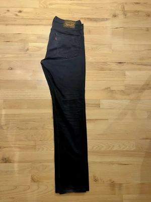 Levi's 511  straight fit mörkgrå jeans W32 L34 - Säljer ett par mörkgrå Levi's 511 jeans med klassisk femficksdesign och rakt snitt i bra skick. Jeansen har en straight passform och är tillverkade i bomullsmaterial med lite stretch. Snygga detaljer som den röda Levi's-taggen och läderpatch bak i midjan. Notera att sista bilden på bakfickan är taget med skarpare ljus så de uppfattas lite mörkare.