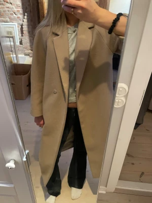 Beige kappa från H&M  - Stilren beige/ljusbrun kappa från H&M. Kappan är storlek XS, men passar mig som vanligtvis bär S☺️🩷