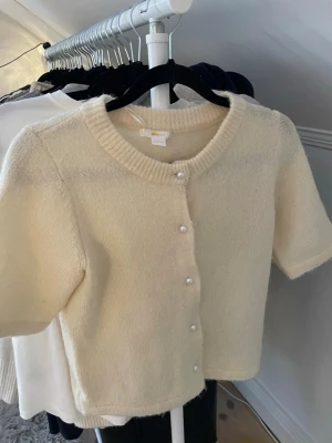 Ljusgul kortärmad stickad kofta  - Supersöt ljusgul stickad kofta med pärlknappar. Har inga fel eller något utan är bara lite kort på mig!❤️