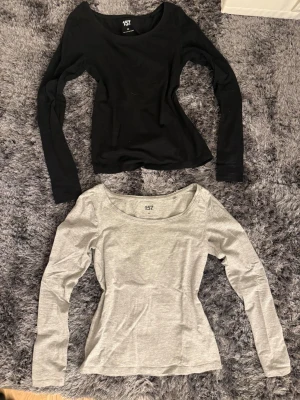 2 långärmade toppar  - Säljer två basic långärmade toppar i storlek XS. En är helsvart och den andra är ljusgrå. Båda har rund halsringning och är tillverkade i mjuk bomullsblandning med lite stretch för skön passform. Båda för 50!!