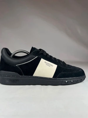 Valentino Upvillage - Säljer ett par svarta Valentino Upvillage i storlek 44 men passar 45. Skorna är knappt använda, vilket tydligt syns på sulan, och är i mycket fint skick.  De har använts varsamt och är väl omhändertagna. Perfekta för dig som vill ha ett par stilrena designersneakers i nära nyskick.  Pris kan diskuteras vid seriöst intresse. Hör av er om ni har frågor eller vill ha fler bilder!