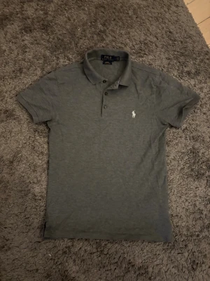 Polo Ralph Lauren Pike - Säljer en stilren grå pikétröja från Polo Ralph Lauren. Storlek S