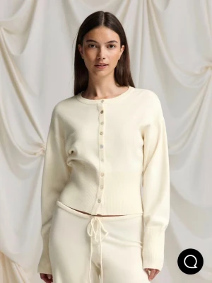 Krämvit kofta från Gina Tricot - Supermjuk krämvit kofta med rund hals och långa ärmar från Gina Tricot. Koftan har ribbade muddar, smala knappar framtill och är stickad i ett skönt material. Perfekt att slänga på sig över ett linne eller t-shirt. Ny med prislapp kvar!