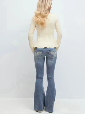 Gina Tricot jeans - Snygga ljusblå bootcut jeans från Gina Tricot med slitna detaljer på benen och broderade bakfickor. Jeansen har mid midja och är tillverkade i klassiskt jeansmaterial. Perfekta för dig som gillar en avslappnad men trendig look.