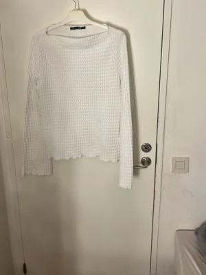 Vit stickad långärmad tröja - Säljer en vit stickad tröja med långärmad design och rund hals. Tröjan har ett snyggt strukturerat mönster och vågig kant nedtill. Perfekt för dig som gillar enkel och stilren look. Pris kan diskuteras och tvätt ingår     