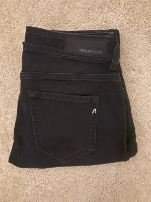 Svarta Replay jeans i ekologisk bomull - Snygga svarta jeans från Replay i modellen Faaby, tillverkade av ekologisk bomull. Klassisk femficksdesign med raka ben och diskret Replay-logga på bakfickan. Passar dig som gillar stilrena och tidlösa jeans med bekväm passform.