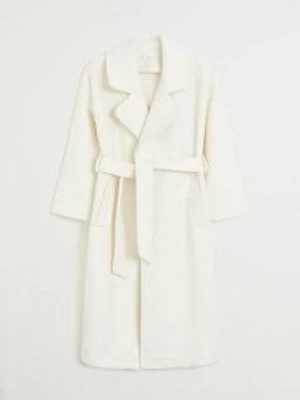 Vit kappa med bälte från Mango - Säljer en stilren vit kappa från Mango med klassisk krage och knytbälte i midjan. Kappan har två fickor och är tillverkad i mjukt ullmaterial. Nypris:1300 kr