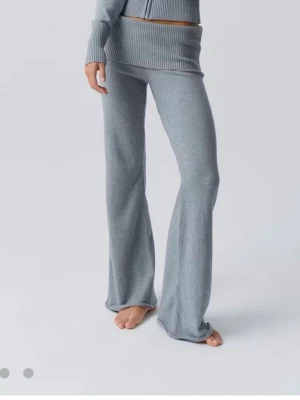 Grå ribbade mjukisbyxor med wide fit - Säljer ett par grå mjukisbyxor med bred ribbad midja och riktigt skön wide fit. Byxorna är stickade i mjukt material och har en avslappnad look som passar perfekt till chill dagar. De ör low waist men om man viker upp dem så blir de high waist