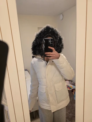 Vit pufferjacka med päls från Norrsken - Säljer en vit pufferjacka från Norrsken med fluffig svart/grå fuskpäls på huvan. Perfekt för kalla vinterdagar!! Använts bara några gånger, så som nytt och priset kan diskuteras 💕 kan inte hitta nypris till den men jackor från Norrsken brukar kosta 2 till 5 tusen. Det står ingen storlek men skulle säga det är M, själv brukar ha storlek s kläder. 