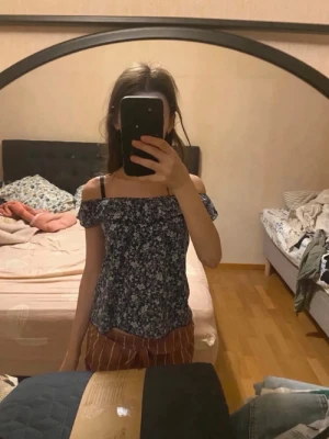 Blommig topp - Söt offshoulder topp med blommigt mönster i blått och vitt. Toppen har korta ärmar och en luftig passform.