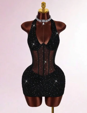 Svart glittrig kortklänning  - Supersnygg svart kortklänning med glittriga detaljer och meshpaneler som ger en cool och edgy look. Klänningen har en djup v-ringning, är ärmlös och figurnära passform. Perfekt för dig som vill sticka ut med en glamorös vibe och markerad midja. Köpt för 599kr och aldrig använt då den tyvärr inte passade mig 