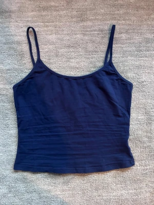 Marinblått linne - Säljer mitt marinblåa linne i mycket bra skick som jag endast använt ett fåtal gånger. Linnet har justerbara band. 