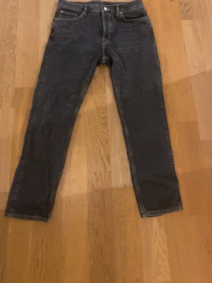 Weekday Jeans - Säljer ett par mörkgrå Weekday Pine Regular Tapered Jeans i storlek 31/30. Jeansen har klassisk femficksdesign, raka ben med avsmalnande snitt och är tillverkade i 100% bomull. Snygga kontrastsömmar och läderpatch med Weekday-logga bak i midjan.