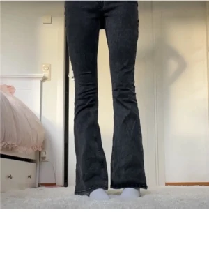 Bootcut svarta jeans med låg midja - Snygga mörkgråa bootcut jeans från Gina Tricot i strl 34💕! Passar så bra till det mesta och sitter väldigt skönt! Säljer dessa för att de är lite för korta för mig, 175cm lång❤️