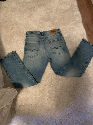 Replay ljusblå jeans Thad - Säljer ett par ljusblå jeans från Replay, modell Thad. Jeansen har klassisk femficksdesign, snygga detaljer på bakfickorna och en skön passform. Materialet är jeans och de har en rak siluett med normal midja. Perfekta för dig som gillar stilrena och bekväma jeans. Har använt dom max 4 gånger, så i super skick!