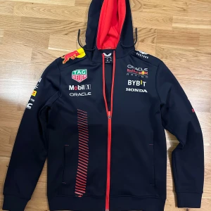 Red Bull F1 Team Zip Up - Riktig snygg och exklusiv tröja från redbull f1 team! Storlek S men kan passa M med! Inga defekter förutom att lite av trycket lossnat - checka bilderna! Nypris på nästan 2k! Skriv gärna vid vad som ✌️