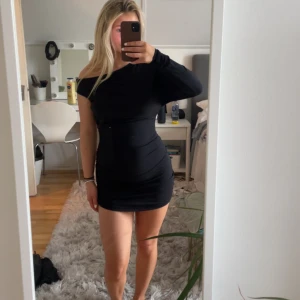 Svart klänning  - Säljer denna svarta supersnygga klänning, helt oanvänd med lappen kvar. Super snygg, stretchig och skön i materialet.