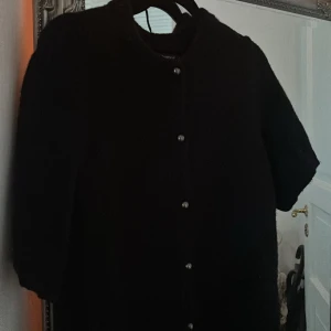 Svart stickad kofta från Gina Tricot  - Svart stickad kofta med korta ärmar och rund halsringning. Använd 1 gång🤍 