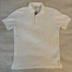 Burberry piké  - Säljer en vit Burberry piké som är helt ny. Storlek XL men passar även L. Hör av er vid fler frågor.