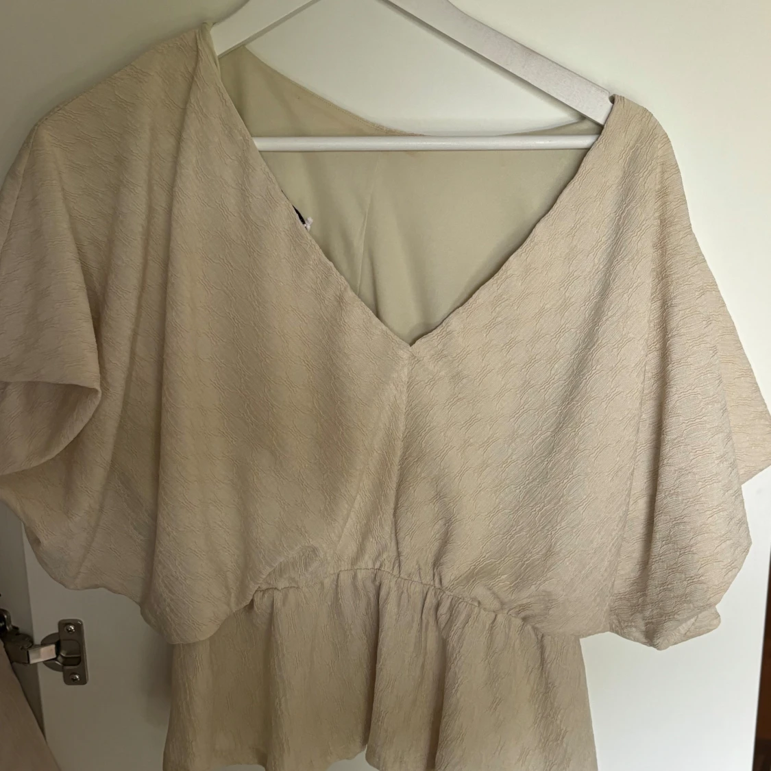 Beige blus med volang och v-ringning - 1