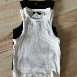 Ribbade linnen från Bik Bok, svart & vit - Två ribbade linnen från Bik Bok i storlek S, ett i vitt och ett i svart. Klassisk ärmlös modell med rund halsringning och tight passform. Perfekta att matcha med jeans eller kjol för en clean look. Mycket bra skick. Nypris på deras hemsida är 99kr/styck❤️