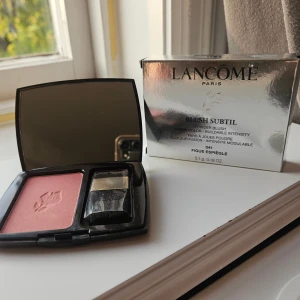 Lancome Blush Subtil Figue Espiègle - Lancome Blush Subtil i nyansen Figue Espiègle, en puderrouge i en mjuk rosa ton. Kommer i en svart kompakt dosa med spegel och liten borste. Perfekt för att ge kinderna en fräsch och naturlig färg. Testad några få gånger men tonen passade inte mig.