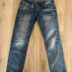 Blå jeans från Jack & Jones Comfort Fit - Säljer ett par snygga blå jeans från Jack & Jones med Comfort Fit/Mike-passform. Storlek 34 i midjan och 30 på längden. 