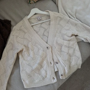 Beige stickad kofta från Sincerely Jules - Superfin beige stickad kofta från Sincerely Jules med snyggt vågigt mönster och v-ringning