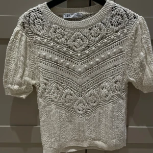 Vit stickad blus från Zara - Superfin vit stickad blus från Zara med korta puffärmar och rund halsringning. 