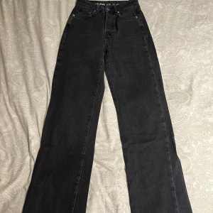 Svarta wide jeans från Never Denim - Säljer ett par svarta wide leg jeans från Never Denim i storlek 26/32. Hög midja och raka, breda ben. Klassisk femficksmodell.
