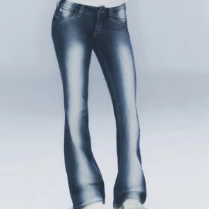 Blå bootcut jeans med slitningar - Snygga blå bootcut jeans med ljusa slitningar längs benen och klassisk femficksdesign. Jeansen har normal passform och är perfekta för en avslappnad och trendig look. Dom är helt i nyskick och aldrig använda 