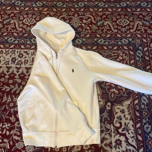 Polo Ralph lauren - Tja! Säljer min vita polo Ralph lauren zip Huddie för att den har blivit för lite för mig och jag har knappt använt den. Den är så i ny skick o självklart äkta. Skick-10/10, vid snabb affär kan priset diskuteras, vid mer frågor hör av er 🫡🚨är även öppen för byten, ifall någon har en storlek M!