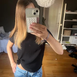 Svart basic t-shirt i bomull - En enkel svart t-shirt med rund hals och korta ärmar. Modellen är normal i passformen och tillverkad i mjuk bomull. Perfekt att matcha med jeans eller shorts för en clean och chill look. Sjölv tycker jag det blir snyggare om man sätter en klämma för att den inte ska se för lång ut men samtidigt har jag en kort överkropp och är 160. Passar mig oversized som XS