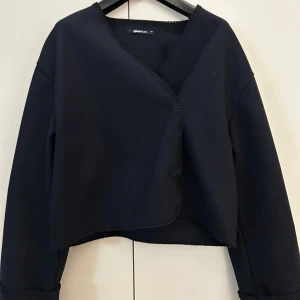 Mörkblå kort kappa från Gina Tricot - Jätte fin kort kappa. Har bara använts vid 3 tillfällen. Varan är från Gina tricot och tror ej den finns kvar på försäljning hos dom. Säljer då jag fått upp ögonen för en annan kappa😊