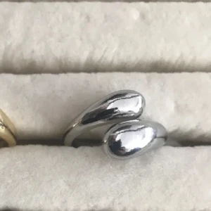 Silverfärgad ring - Säljer en stilren och elegant silverfärgad ring. Den har en bred design som ger ett modernt och tidlöst intryck. Perfekt för både vardag och fest!