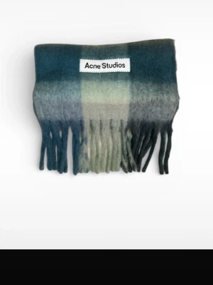 Rutig blå-grön halsduk Acne Studios - Säljer en snygg rutig hallsduk från Acne Studios pga att den var fel färg när jag fick den i present. Halsduken har en mix av blå, grön och grå toner med fransar nedtill och en tydlig Acne Studios-label framtill. Perfekt för dig som vill ha en cool och trendig look. PRIS GÅR ATT DISKUTERA. 