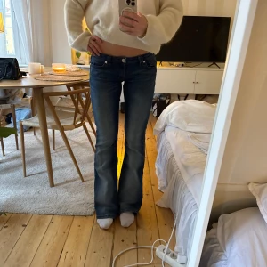 Blå bootcut Lågmidjade jeans  - Snygga blå Lågmidjade bootcut jeans / low waist utsvängda jeans, liknande de från True Religion. Dessa är från Gina tricot! Strl s. Midjemått ca 38 cm och innebenslängden ca 84 cm