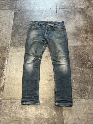 Vintage Nudie Jeans - Grim Tim - Tja! säljer nu ett otroligt snyggt par nudie indigo scraped i modellen grim tim 34/32👏 det här är en otroligt snygg och eftertraktad sort av grim tim och är väldigt svåra att få tag på med tanke på att de inte producerats på många år🫡 tveka inte på att skriva ifall ni har frågor!