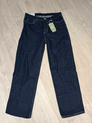 Mörkblå raka jeans från H.M, Loose fit - Snygga mörkblå jeans från Levis med klassisk femficksdesign och kontrastsömmar. Modellen har rak passform och normal midja, perfekt för dig som gillar en enkel och tidlös stil. Materialet är slitstarkt jeans och byxorna har knapp och dragkedja framtill.