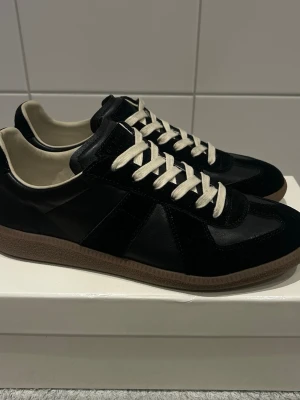 Äkta Maison margiela gats 42 - Ett par nästan helt nya Maison margiela gats i storlek 42. Äkta. Kvitto finns.  Säljer pågrund av att dem inte kommer till så mycket användning då jag har växt ut dem. 😀