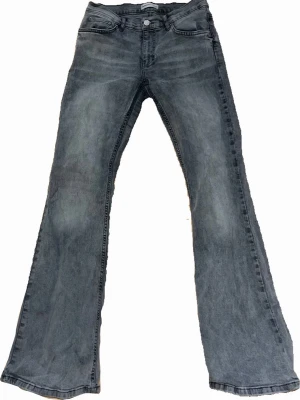Grå bootcut jeans med låg midja - Säljer ett par gråa bootcut jeans med låg/mid waist. De är lite trasiga längst ner på benen på baksidan. Original priset var 500kr