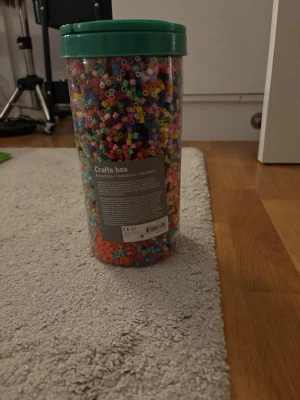 En stor behållare med färgglada pärlor - En stor behållare med färgglada pärlor för pyssel. Skicka för fler bilder. Går att köpa i bundle med annat.