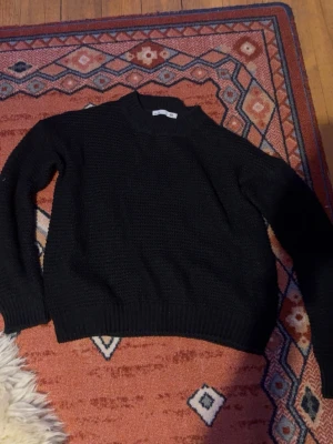 Svart stickad tröja från lager 157 - En svart stickad tröja från 157 i storlek XS. Tröjan har en formlig passform med ribbade muddar vid ärmslut och nederkant samt högre rund halsringning. Perfekt - enkel men ändå snygg till alla outfits. Jätte skön att bara slänga på sig å passar till allt. Säljer då den är för liten på mig då jag är lång. Passar nog perfekt på dig som har XS.